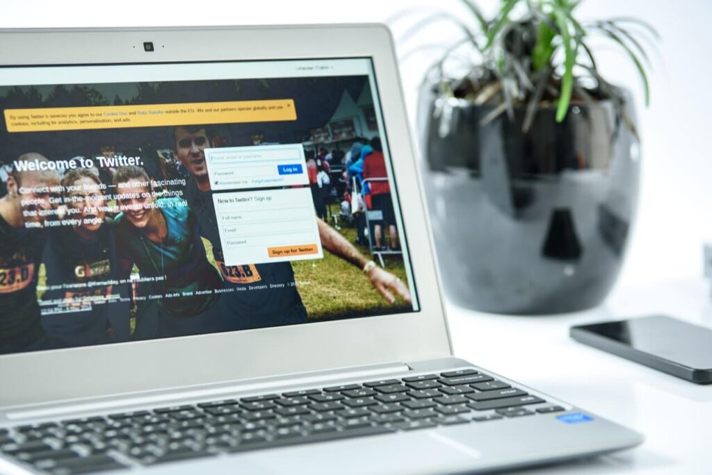 Image shows a laptop screen, showing the Twitter login/sign up page